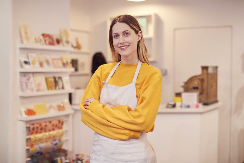 Portrait Of Smiling Female Small Business Owner Standing Inside Shop On Local High Street